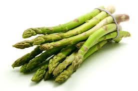 Bright green asparagus spears arranged on parchment with a sprinkle of sea salt—farm-fresh, exotic, and ready for clean gourmet cooking.