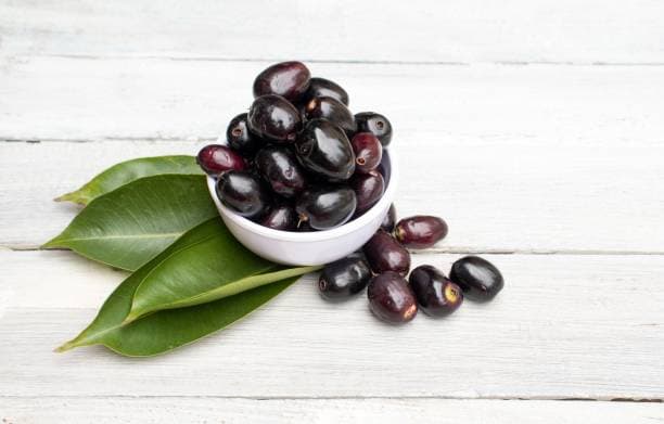 Fresh organic black jamun displayed on a natural surface, clean and ready to use.
