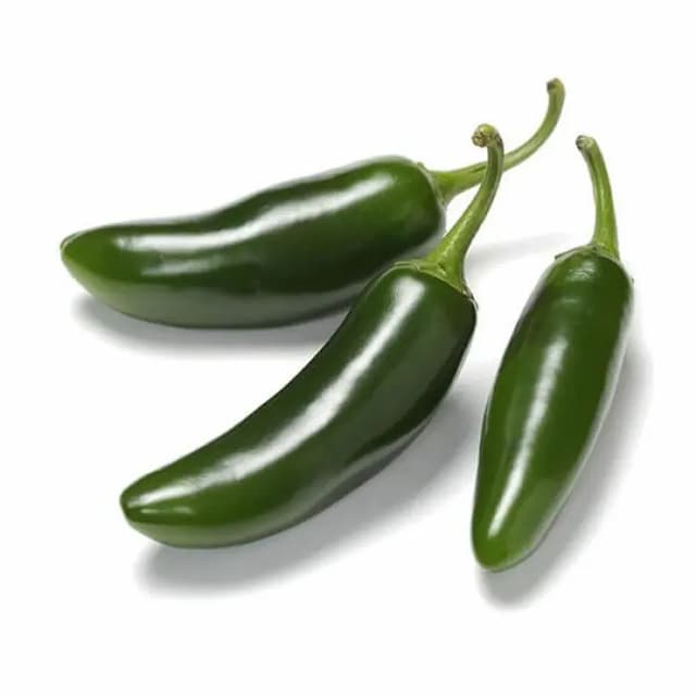 Shiny green organic jalapeño peppers laid flat on a dark board—bold, spicy, and part of our premium exotic vegetable collection.